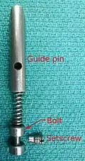 10. The pin, spring, bolt and setscrew as arranged in the sliding block.