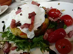 Bubble and squeak with poached egg, rocket, and tomatoes.