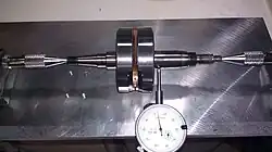 Crankshaft alignment achieved using a home made tool: two modified plumb-bobs mounted to a machined aluminum plate.