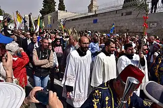 Procession - a number of people or vehicles moving forward in an orderly fashion, especially as part of a ceremony