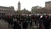 Crowd of people in Copley Square, Boston. Many are holding signs.