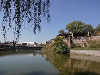 A photograph of a walled structure abutting a river