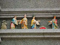 The human-shaped sculptural decorations on the exterior wall.