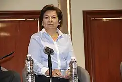 Isabel Miranda is seated in front of an audience.