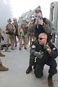 Greek Navy Warrant Officer Alexander Tsaltas demonstrates tactical sweep techniques for U.S. Marines with the 26th Marine Expeditionary Unit's maritime interception operations assault force aboard the training ship HNS Aris in Souda Bay, Crete, Greece