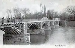 Black and white photograph of a bridge over a river.