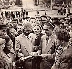 Black and white photo of attendees to 1958 Afro-Asian Writers' Conference gathered around a book.