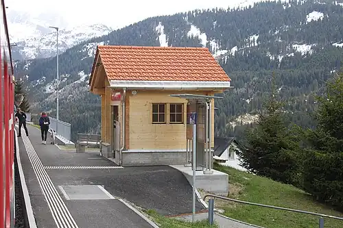 Single-story shelter on a platform with mountains behind