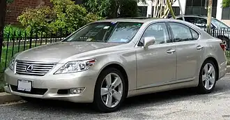 Front three-quarters view of gold sedan
