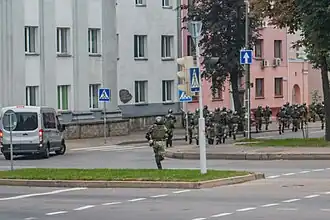 Running internal troopers in Minsk. Note the van with darkened glasses and without the registration plate: such vans are reported to be used by the government forces to bring reinforcements and detain people[315][316]