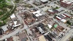 Streets lined with damaged buildings in Sulphur, seen in a daytime aerial shot.