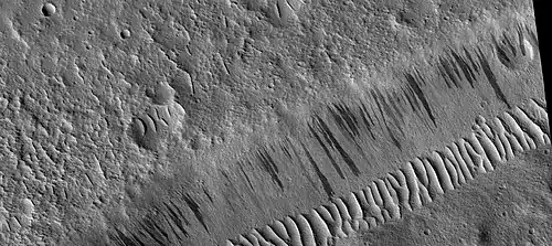Wide view of dark slope streaks on wall of trough.