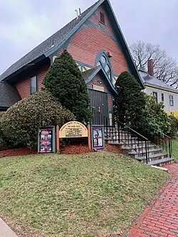 A photo of a building formerly owned by St. John's Episcopal Church, now owned by Arlington Friends of the Drama. This photo depicts the door that was the front door into the church, and now is a door directly into the main theater space.