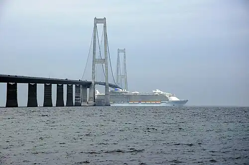 Allure of the Seas passing under the Great Belt Bridge with her funnels lowered.