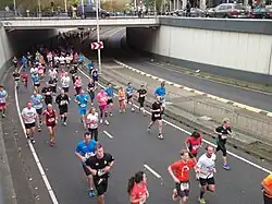 Photo of a group of runners passing underneath a viaduct