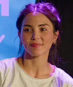 Akana holding a microphone and looking right