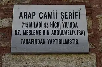 Inscription placed in front of the building in 2013, which records the mosque's legendary foundation by Maslama ibn Abd al-Malik (erroneously put in 715 AD) as its actual foundation date