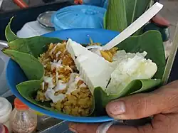 Arroz de lisa (mullet rice) from Barranquilla served in bijao leaf with cooked yuca, a triangle of costeño cheese and a sauce of suero atollabuey.