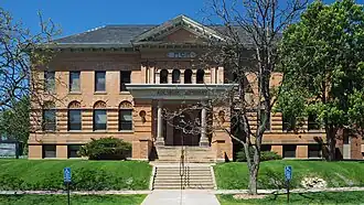 Two-story building on a raised basement with a central entry approached by stairs