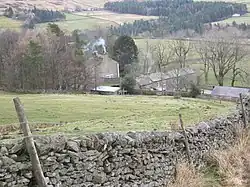 Stone farm buildings among green hills