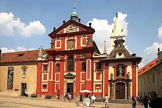 The abbey building, attached to the left of the red-colored Basilica of St. George