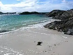 Beach at Port nam Murrach. This small beach is found at the end of a rough walk from the Arisaig road past Rhue House. This view is looking north.