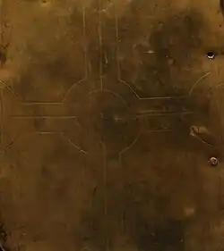 Badly faded outline of the cross engraved on the brass plate of side C