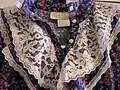 Collar of a 1970s prairie dress, showing common parts of the style such as lace, buttons, floral fabric, and ruffles.