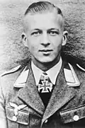 A man wearing a military uniform with an Iron Cross displayed at the front of his uniform collar.
