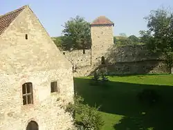 Main court of the Câlnic castle. The building to the left is the chapel. Behind the wall, hills surrounding the village and the castle can be seen.