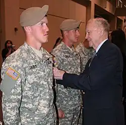 Retired Colonel Ralph Puckett places the Ranger Scroll on two graduates of the Ranger Assessment and Selection Program, January 5, 2010