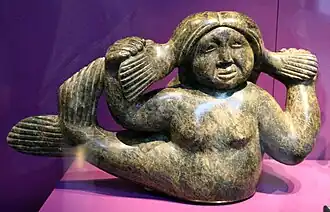 Carving of Sedna, depicted with her legs turned into the tail of a fish, and her fingers cut off.