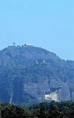 চন্দ্রনাথ মন্দির, যা চন্দ্রনাথ পাহাড়ের চূড়ায় অবস্থিত, ঢাকা-চট্টগ্রাম রেলপথ হতে দৃশ্যমান অবস্থায়। ছবির কেন্দ্রে বিরূপাক্ষ মন্দির দেখা যাচ্ছে।