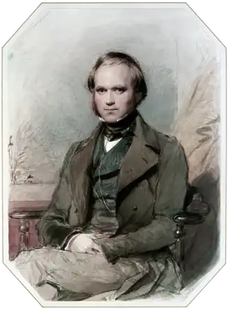 Three-quarter length portrait of Darwin aged about 30, with straight brown hair receding from his high forehead and long side-whiskers, smiling quietly, in wide lapelled jacket, waistcoat and high collar with cravat