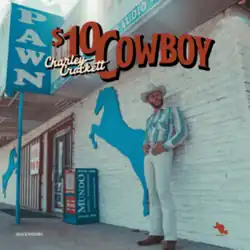 A man wearing a white cowboy hat, patterned shirt and white pants leaning against the white brick exterior wall of a pawn shop, with the title superimposed.