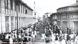 A black-and-white photograph of people running through an urban street