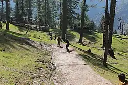 Photo showing children playing tape ball cricket near Pakistani mountains