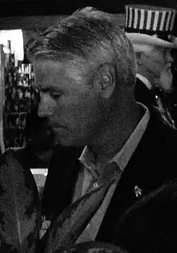 a black and white photo of this person. they are wearing a business suit