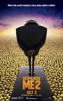 A bald man in dark jacket with his hands behind his back, is standing on a platform and looking out at a crowd of yellow creatures. The film’s tagline reads “When the world needed a hero, they called a villain.”