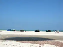 Mini Trucks take people to Land's End, Dhanushkodi, through deep sand and shallows, using planks put under wheels by local kids as the vehicle struggles.