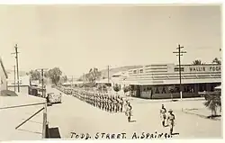A march on Todd Street during World War II, image shows Wallis Fogarty's Store, 1938 - 1948