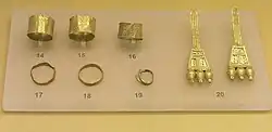 Image 24Finds from an early geometric Cremation Burial of a pregnant wealthy woman, from the N.W. of the Areopagus, about 850 BC, Ancient Agora Museum (Athens); exhibit 14–16: broad gold finger rings; exhibit 17–19: gold finger rings; 20: pair of gold earrings with trapezoid endings (from Greek Dark Ages)