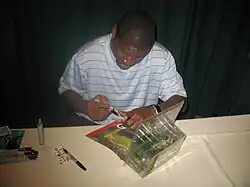 Bennett autographing memorabilia at a table