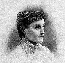 A woman at bust length facing at about 45 degrees from the observer with a neutral expression on her face