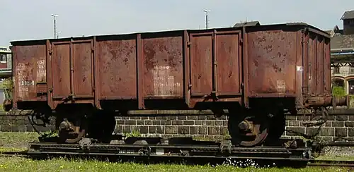 Twin-axled UIC Type 1 open wagon, used as an ash wagon, on a transporter wagon in Zittau