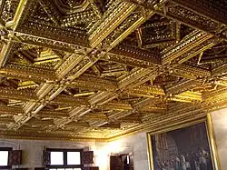 view of the ceiling made of carved wood in squares with smaller squares set inside each as a diamond