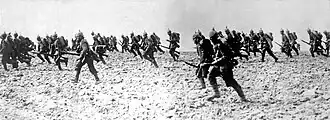 A black and white image of numerous soldiers charging to the left
