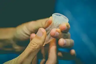 A cup being folded and squished into a cylindrical shape.