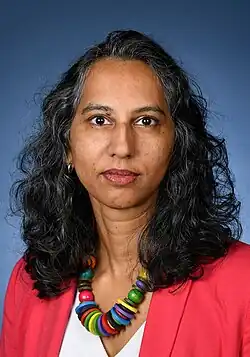 Female with red jacket and colourful necklace