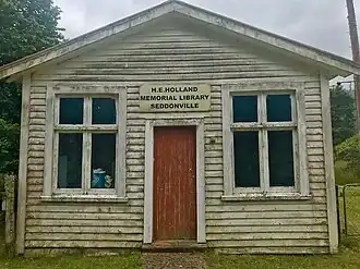 view of a rundown wooden library building